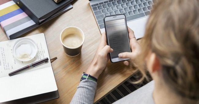 lavoratrice in smartworking che usa telefono